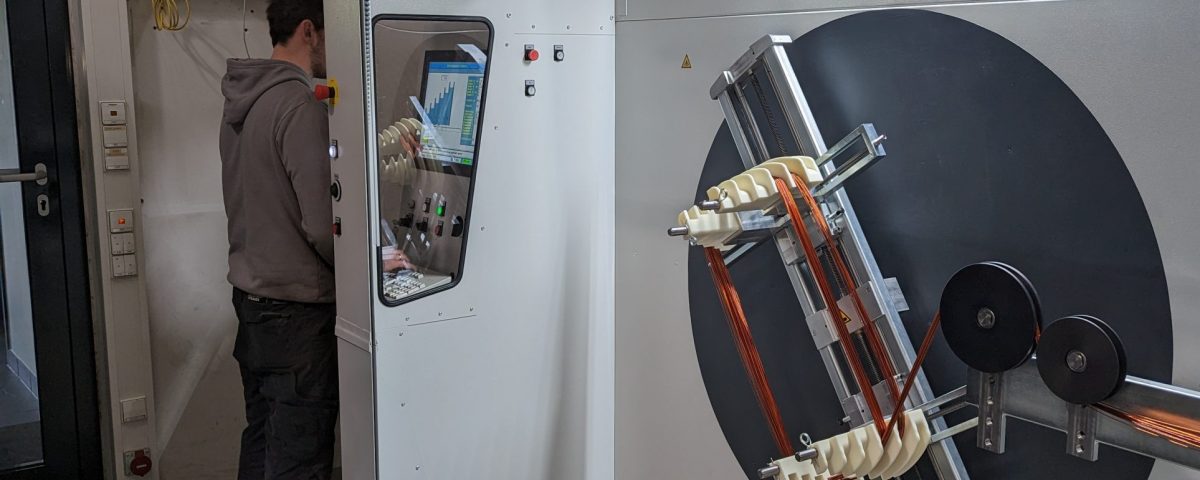 Mitarbeiter bedient computergesteuerte Wickelmaschine für Elektromotoren